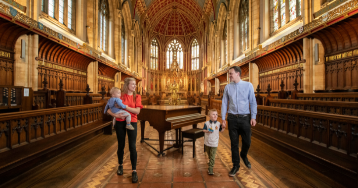 Family mam, dad and two children walking through St Cuthbert's Chapel inside Ushaw Historic House.